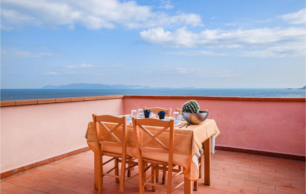 un tavolo e sedie su un balcone con vista sull'oceano di Pet Friendly Home In Cavo With House Sea View a Cavo