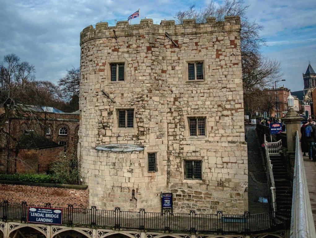 a tall brick building with a flag on top of it at Lendal Tower in York