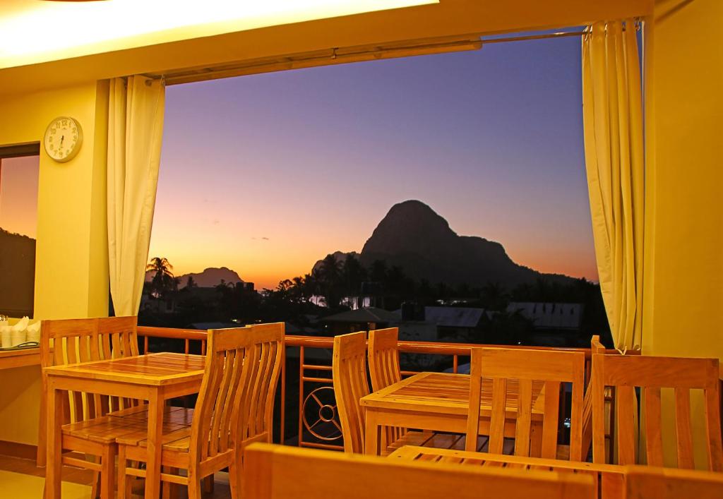 a balcony with chairs and a view of a mountain at Layang Layang Home in El Nido