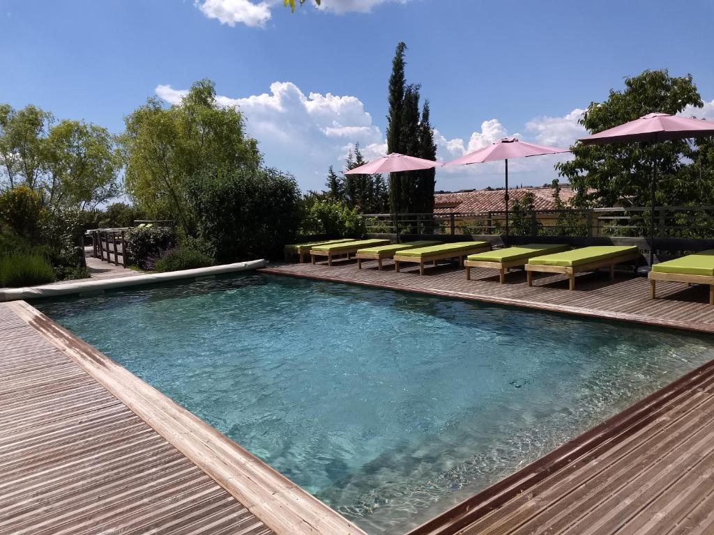 
a pool with a pool table and chairs in it at Les Terrasses de Valensole in Valensole
