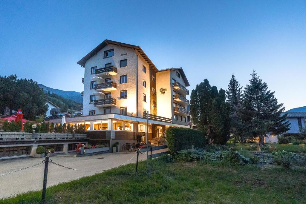 a large building with lights on in a park at Hotel Alpenhof in Unterbäch