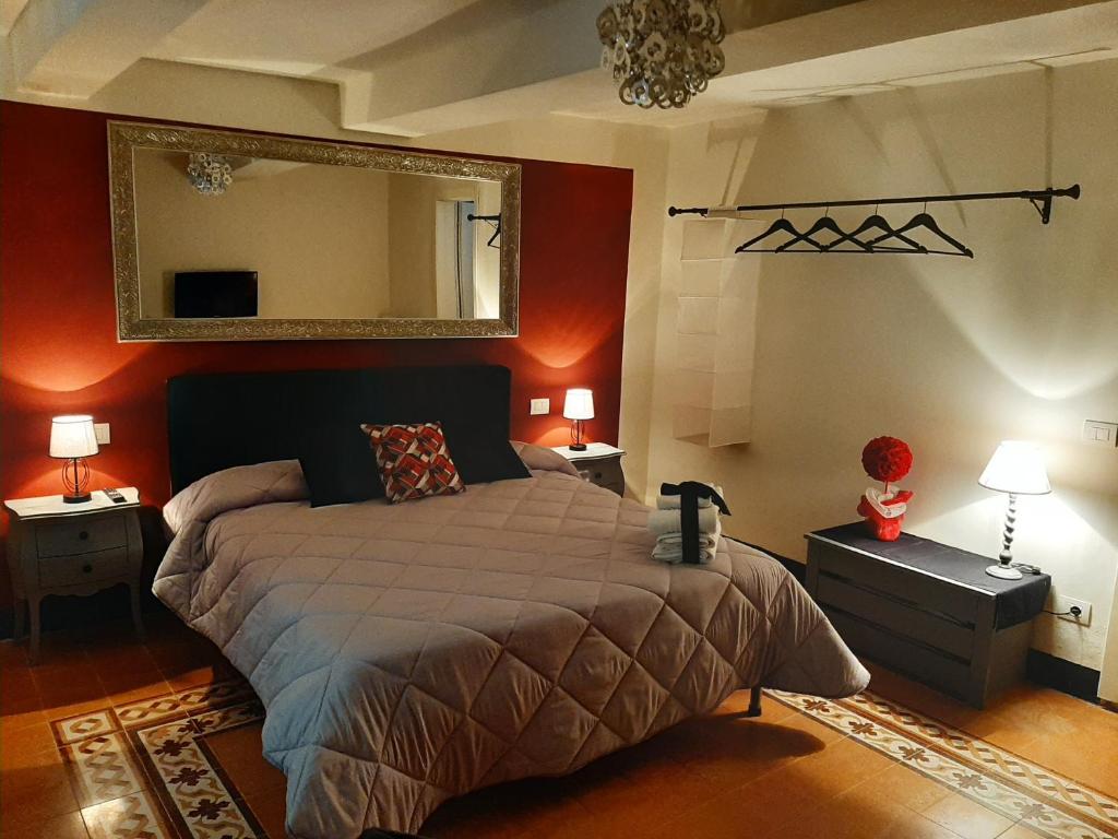a bedroom with a large bed and a mirror at B&B Principe Calaf 3 in Lucca
