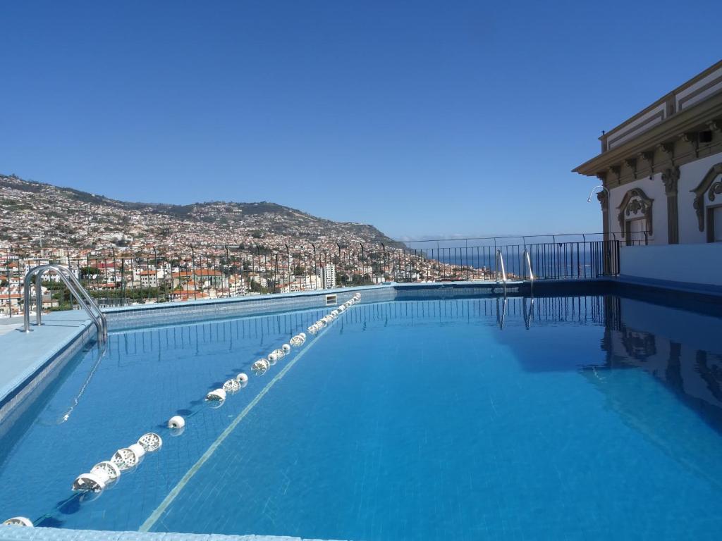 una grande piscina con vista sulla città di Hotel Monte Carlo a Funchal
