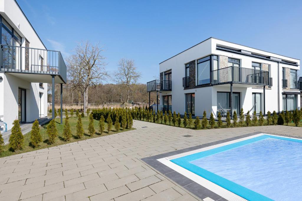 a house with a swimming pool in front of it at Apartament Paraiso by Renters in Łukęcin