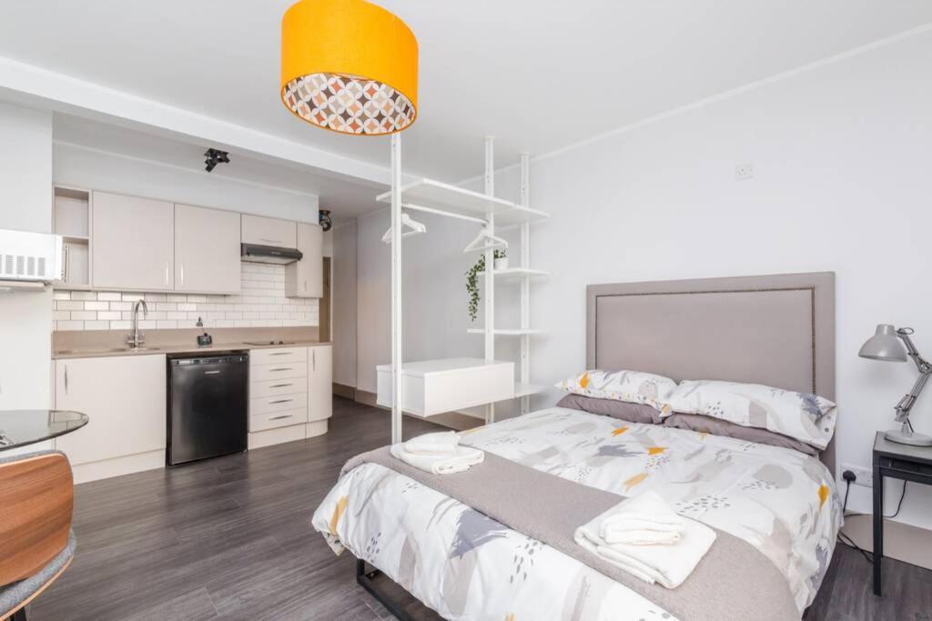 a bedroom with a large bed and a kitchen at CITY HEART BRIGHTON in Brighton & Hove