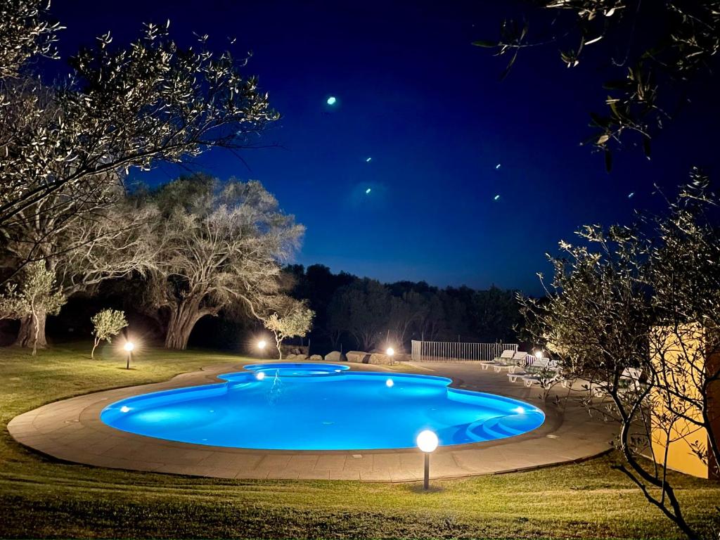 a large blue swimming pool at night at Punta D'Acu Country Resort in Arzachena