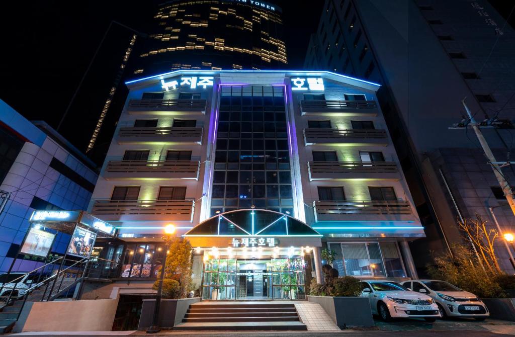 a tall building with blue lights in front of it at New Jeju Hotel in Jeju