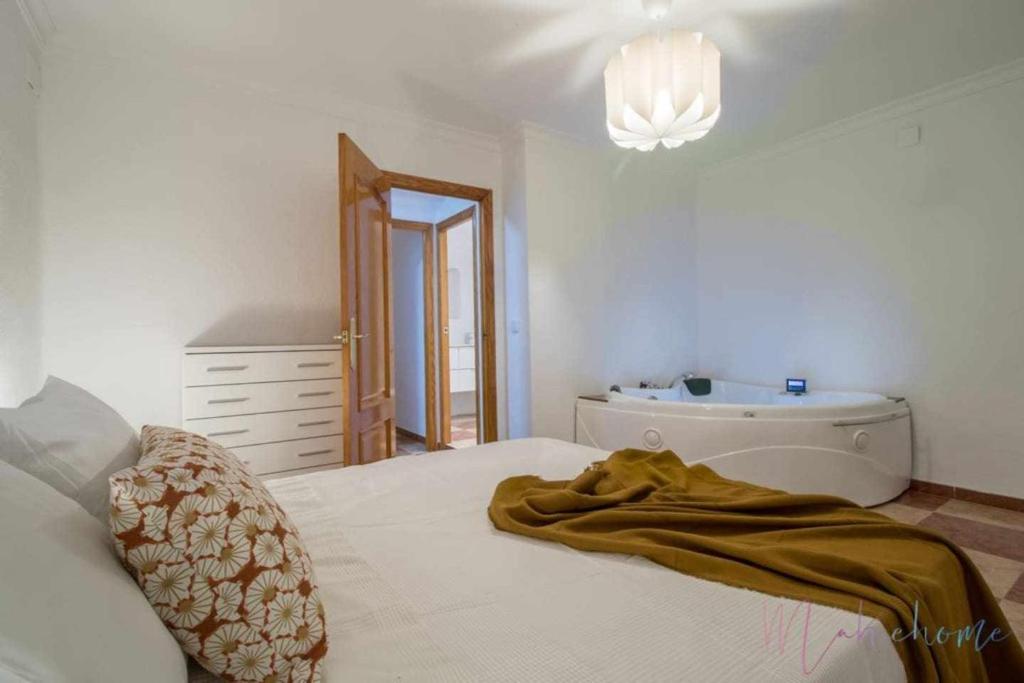 a bedroom with a bed and a bathroom with a sink at Suite con jacuzzi en el centro vistas y garaje in Huelva