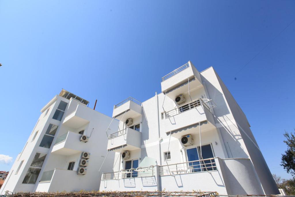 un edificio blanco con balcones frente a un cielo azul en Villa Kristjana Ksamil en Ksamil