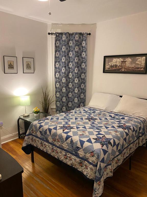 a bedroom with a bed with a blue and white quilt at Hollywood Rentals LLC in Chicago