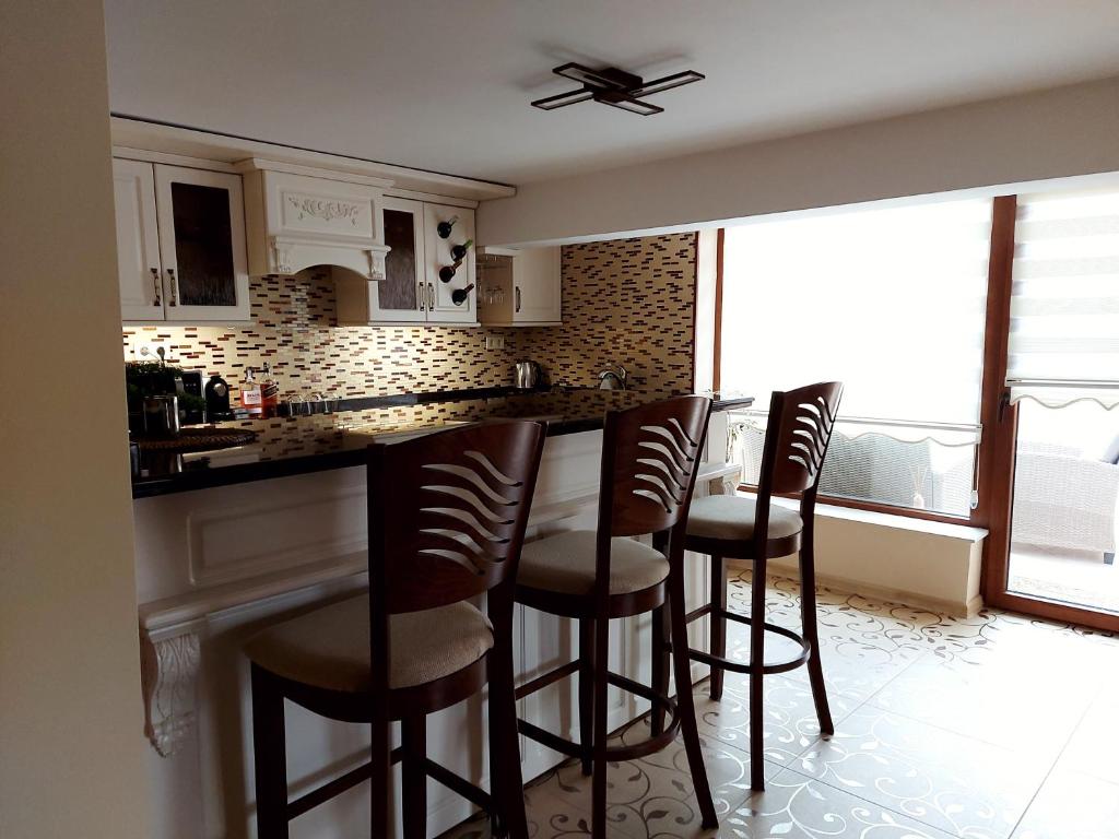 a kitchen with a bar with stools in it at Студио Лидия in Velingrad