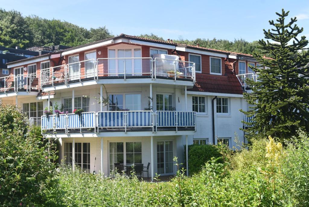 ハリスレーにあるfewo1846 - Am Strand - familienfreundliche Wohnung mit 2 Schlafzimmern, Terrasse und Gartenのバルコニーと木々が備わる大きなアパートメントです。