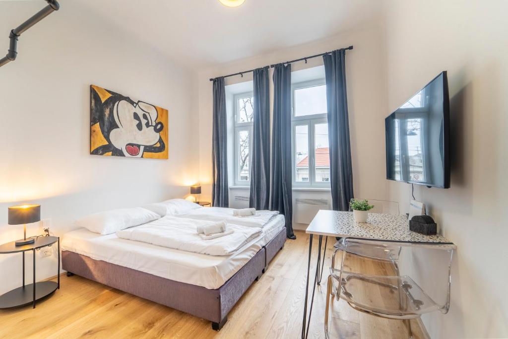 sypialnia z łóżkiem i telewizorem w obiekcie josef's home I Mickey Mouse Apartment w Wiedniu