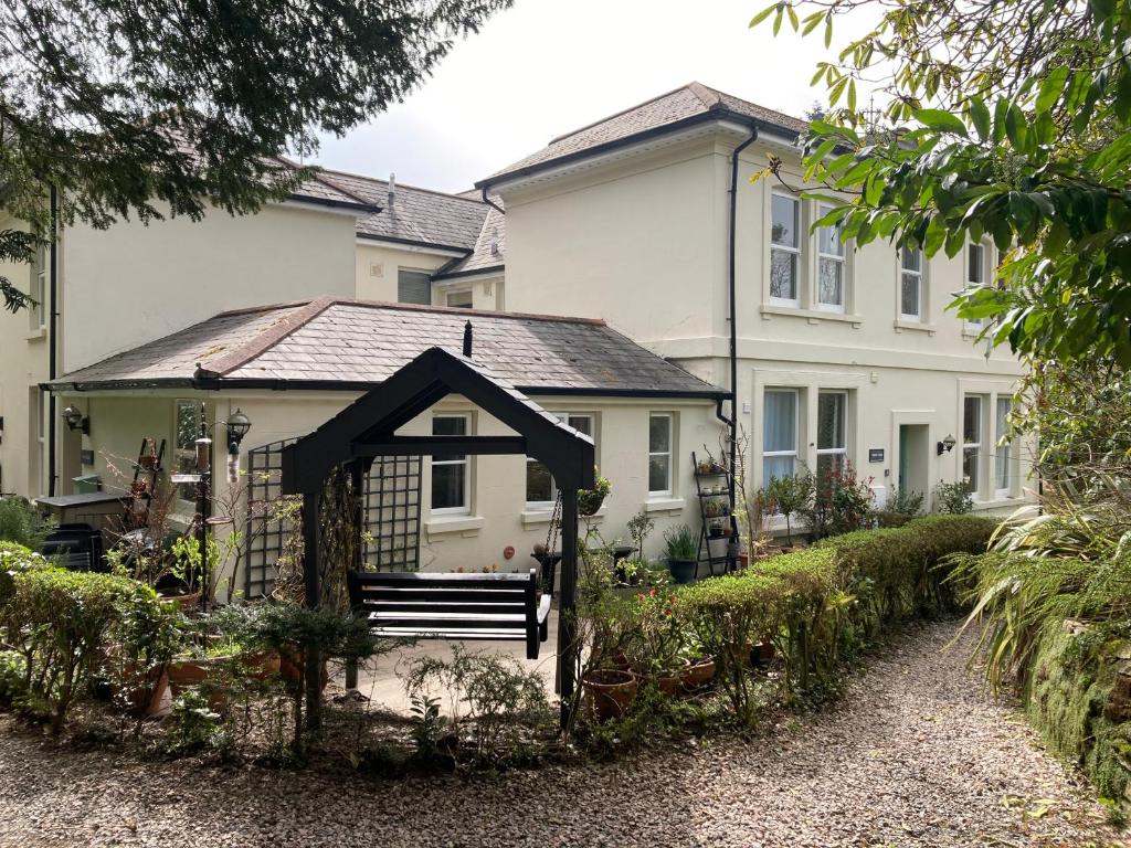 a white house with a bench in front of it at Hollyhocks Holiday Home-Luxury ground floor 2 bedroomed apartment sleeps 5 in Ivybridge