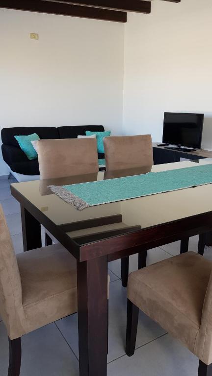 a dining room table with two chairs and a couch at Apartamento Deluxe Senderos del Vino I, con cochera incluida, Desayuno opcional in Mendoza