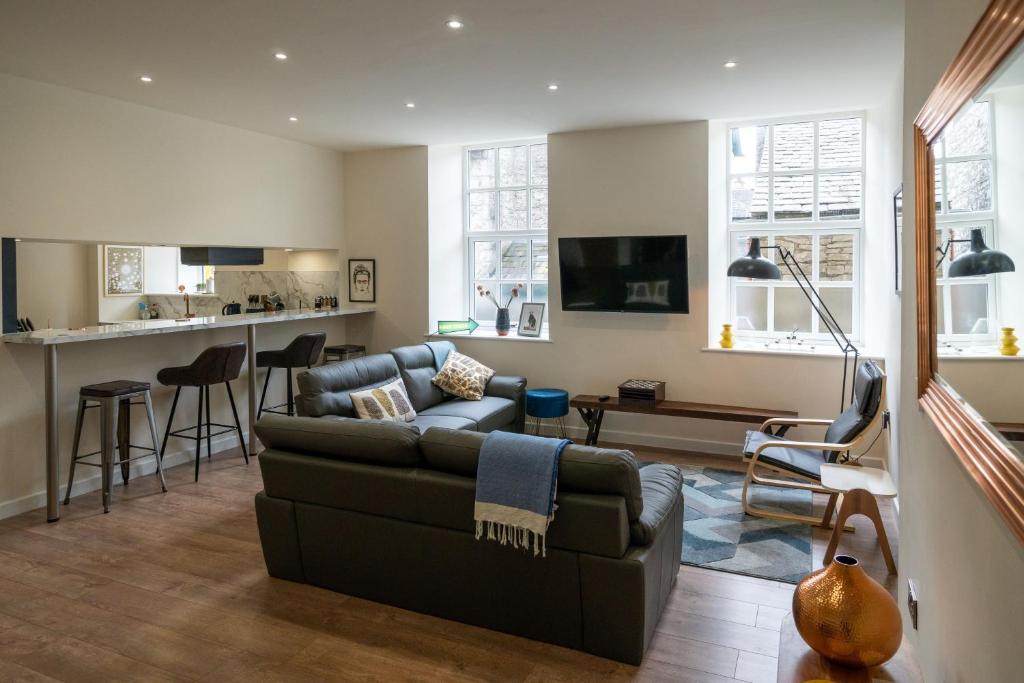 a living room with a couch and a kitchen at 23 Tanners Yard in Kendal