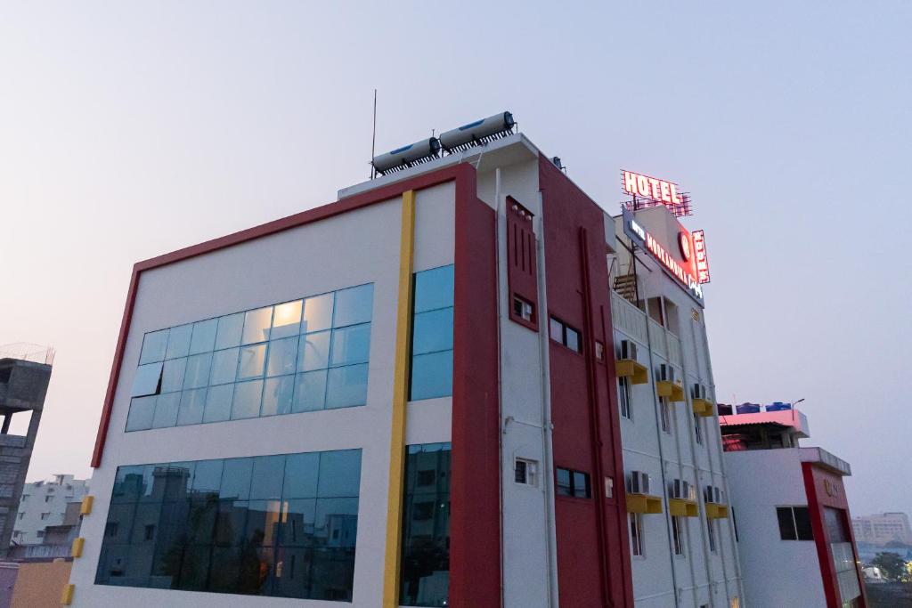 um edifício vermelho e branco com muitas janelas em Hotel Mookambika Comforts em Tirupati