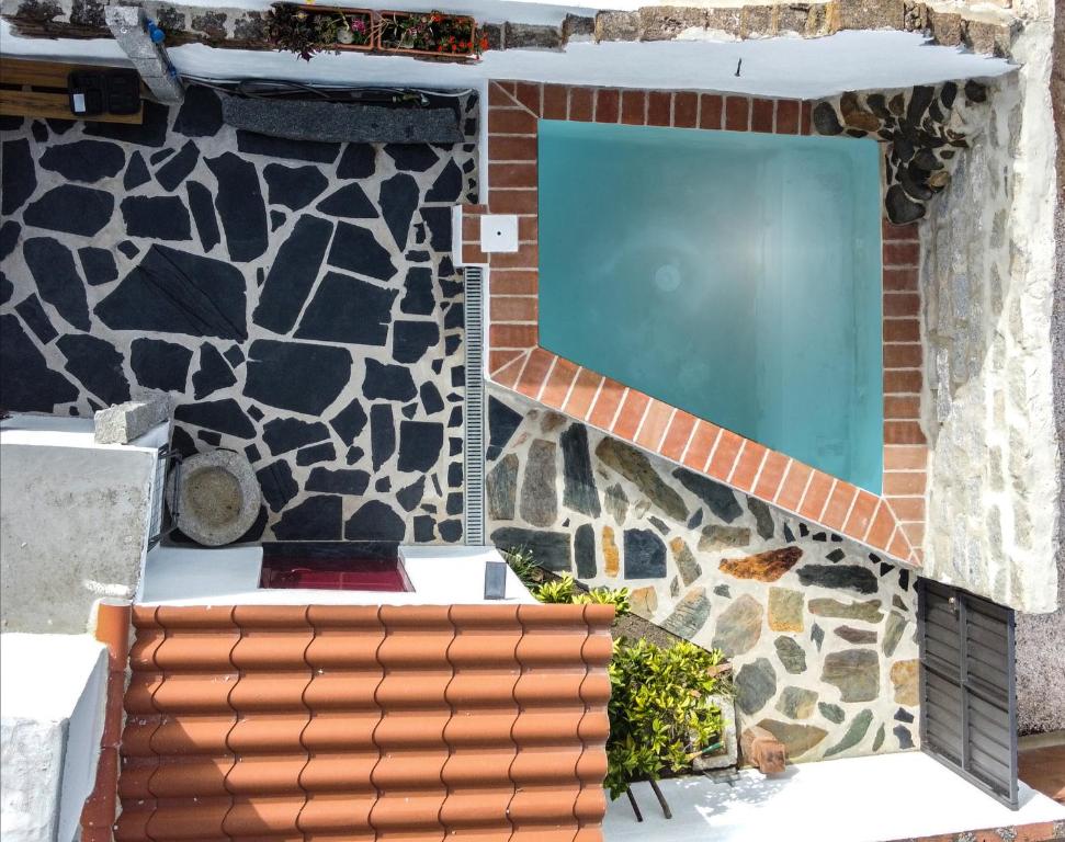 a house with a swimming pool and a stone wall at 17 da Rua da Estação in São Pedro do Corval