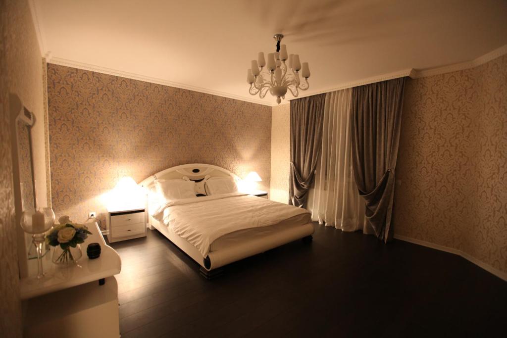 Schlafzimmer mit einem Bett und einem Kronleuchter in der Unterkunft Grace Apartments in Boryspil