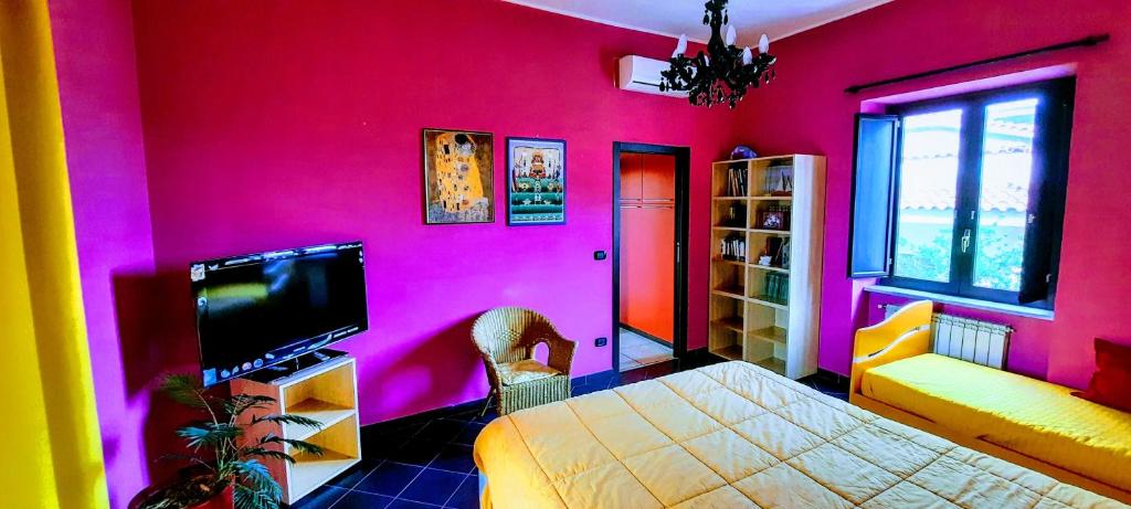 rosa Zimmer mit einem Bett und einem TV in der Unterkunft Oasi di Frattamaggiore in Frattamaggiore