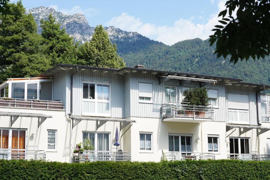 a large white building with mountains in the background at Ferienwohnung Garzmann in Bad Reichenhall