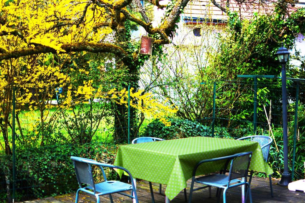 a table and chairs with a table and a green tablecloth at le gite d'Eliane in Masevaux