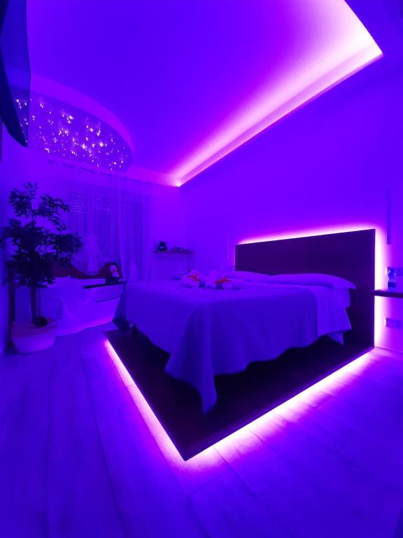 um quarto roxo com uma cama com uma iluminação roxa em Il Mare di Roma Deluxe em Lido di Ostia
