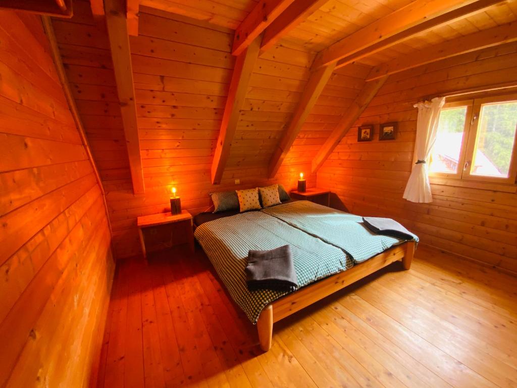 a bedroom with a bed in a wooden cabin at Zirbitz Hütte mit Sauna und Kamin in Sankt Lambrecht