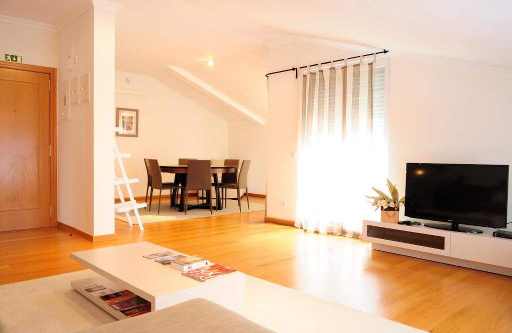 un salon avec une télévision et une table dans l'établissement Cruz Apartments, à Lisbonne