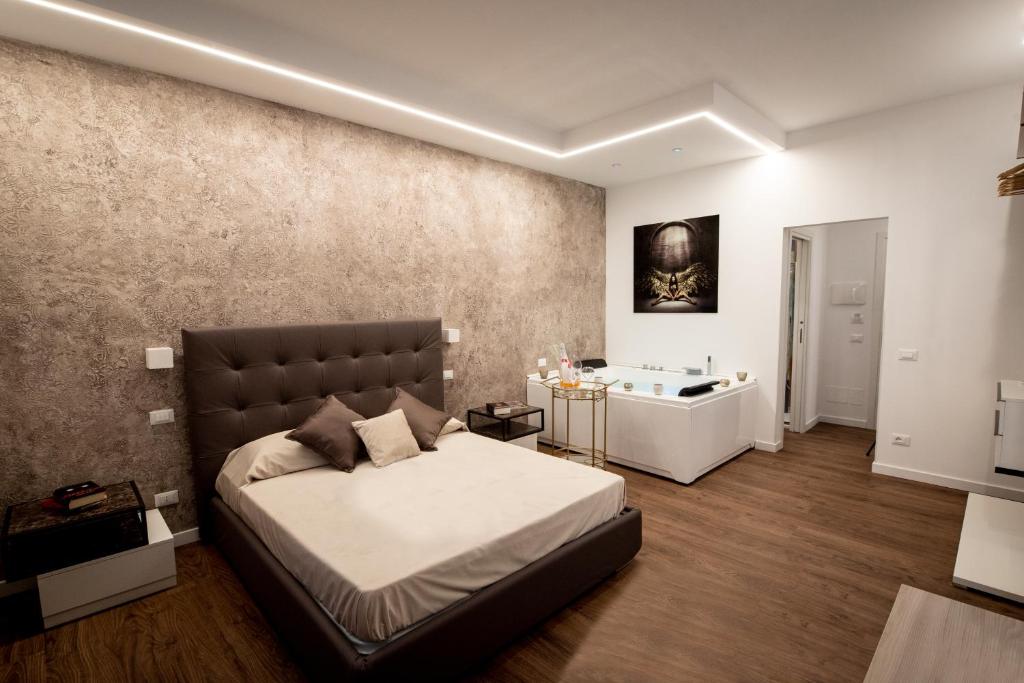 a bedroom with a large bed and a sink at Fervore Luxury Rooms in Palermo