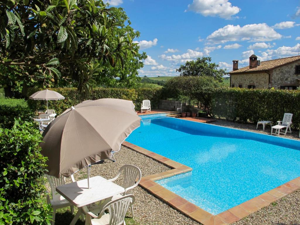 una sombrilla y sillas junto a la piscina en Holiday Home Cignanbianco - Tramonto by Interhome en Castellina in Chianti