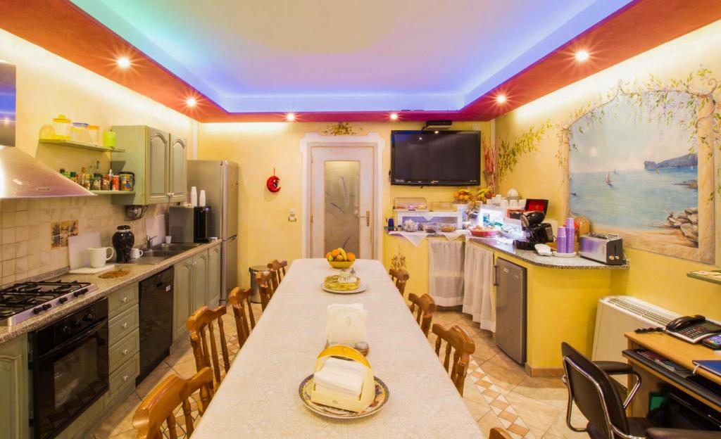 a kitchen with a table, chairs and a microwave at Elisart Guest House in Alghero