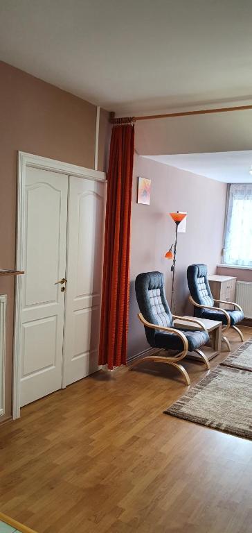 een woonkamer met 2 stoelen en een tafel bij Vénusz Apartman in Cserkeszőlő