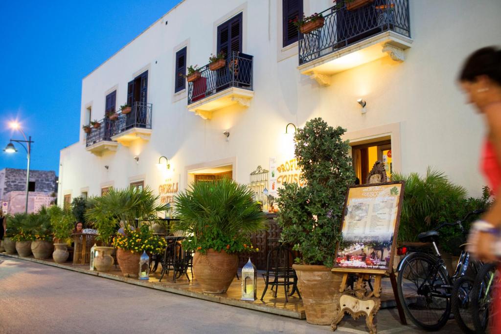 a building with potted plants on the side of a street at Ghibli Hotel in San Vito lo Capo