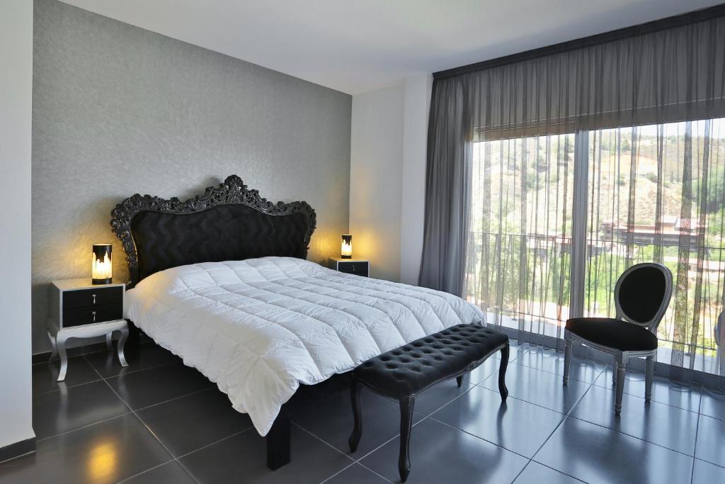 a bedroom with a large bed and a large window at Crystal Hotel in Kakopetria