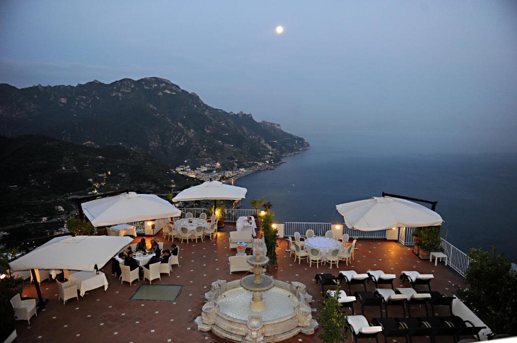 a restaurant with tables and chairs and a view of the ocean at Hotel Villa Fraulo in Ravello