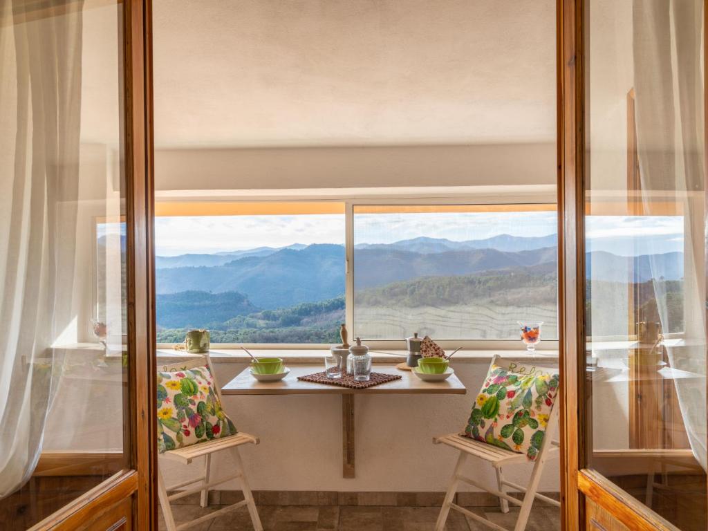 una stanza con tavolo e sedie e una grande finestra di Holiday Home Agapanthus by Interhome ad Arnasco