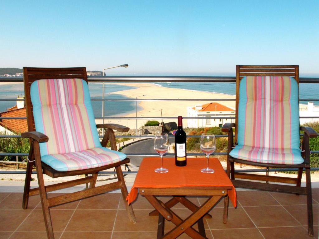 twee stoelen en een tafel met twee glazen wijn bij Apartment Panoramico - FDA115 by Interhome in Foz do Arelho