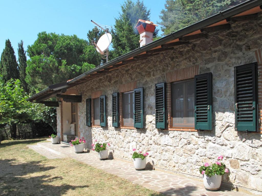 ein Steinhaus mit grünen Fensterläden und Topfpflanzen in der Unterkunft Holiday Home Villetta degli Orti by Interhome in Montemagno