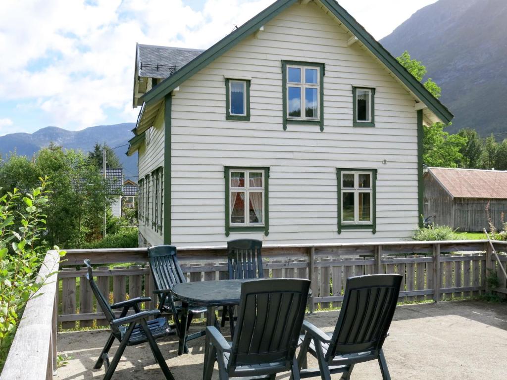 eine Terrasse mit Stühlen und einem Tisch vor einem Haus in der Unterkunft Holiday Home Elvehuset - FJS075 by Interhome in Holsen