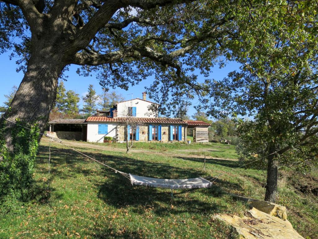 una casa con un árbol y una hamaca delante en Holiday Home Podere Casidote by Interhome, en Montieri