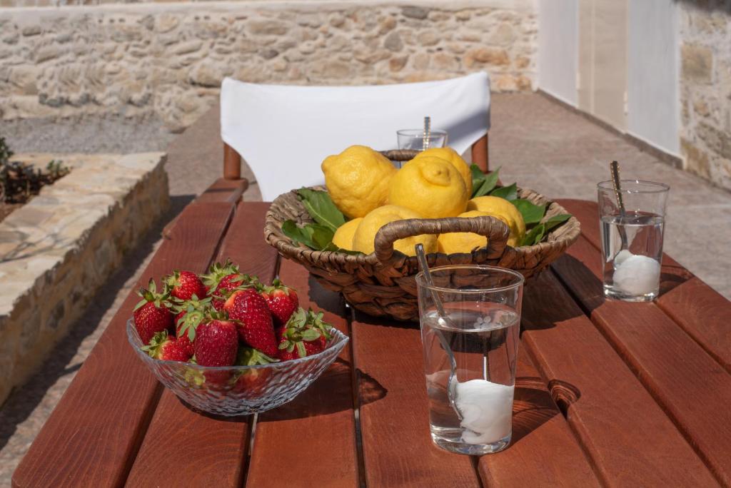 einen Obstkorb und eine Schale Erdbeeren auf dem Tisch in der Unterkunft Zeus Traditional House in Mitrópolis