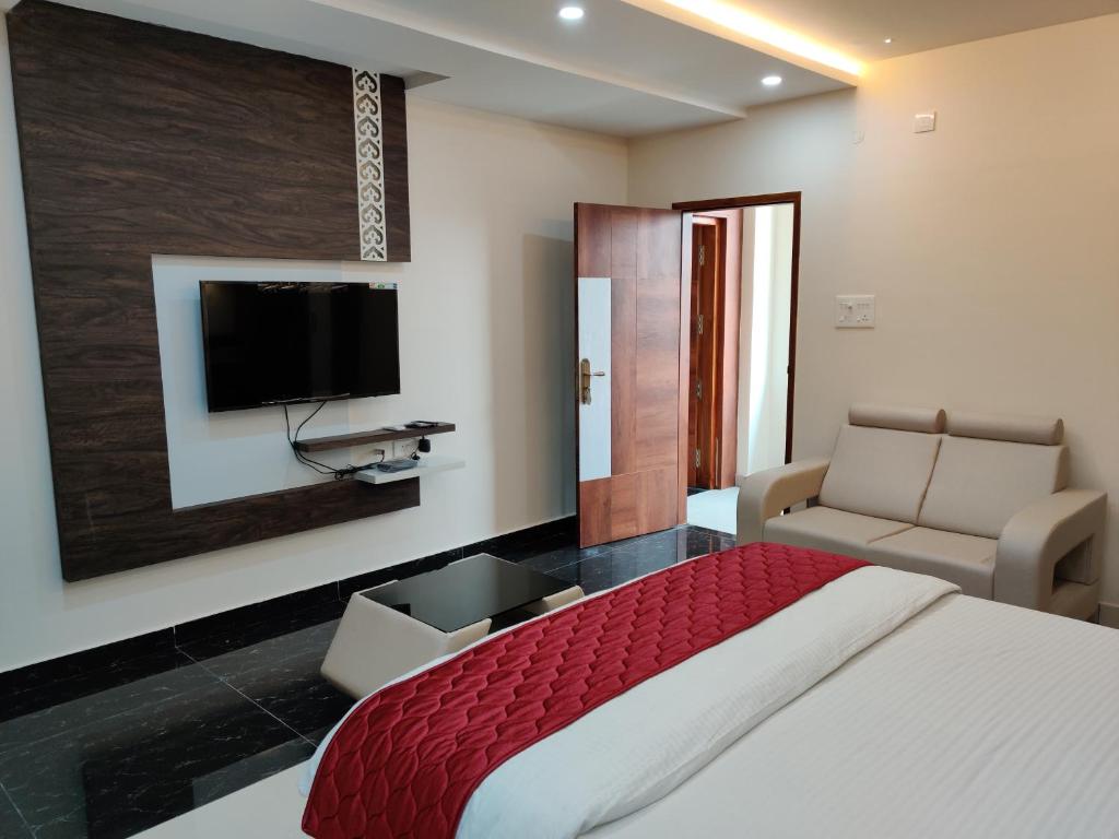 um quarto com uma cama e uma televisão de ecrã plano em Pagadala Grand Residency em Bāpatla