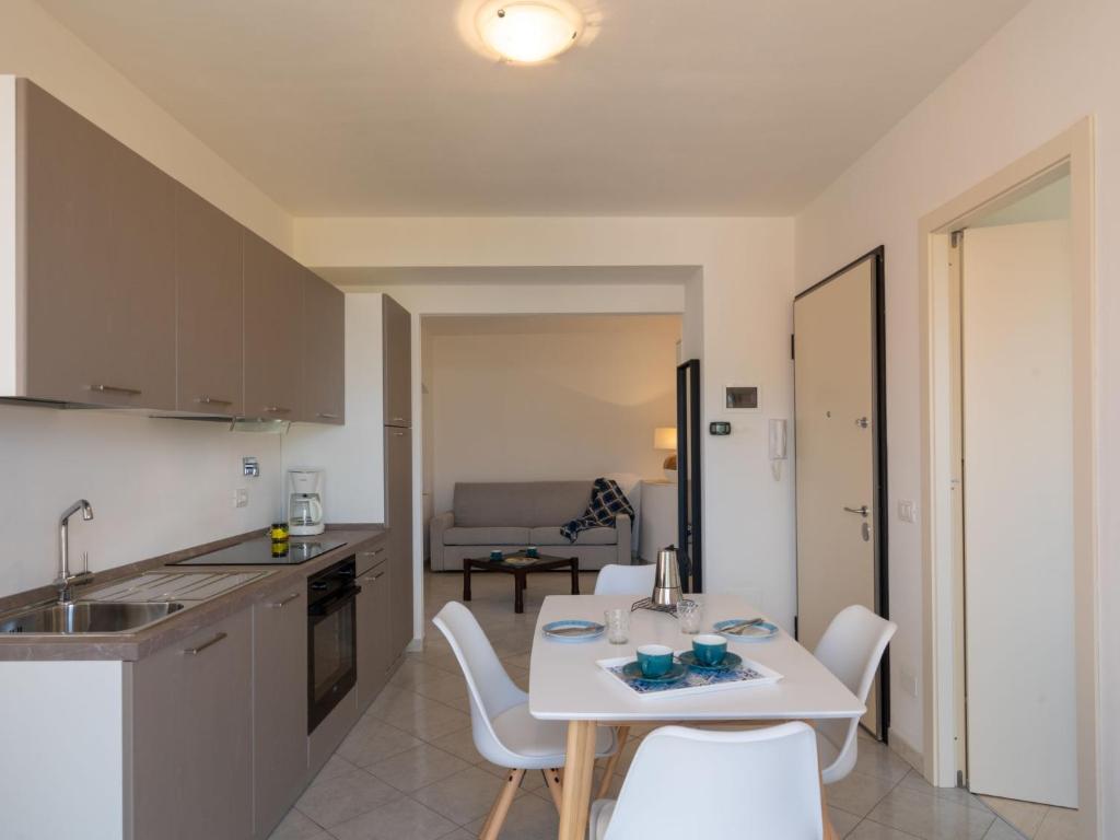 kuchnia i salon z białym stołem i krzesłami w obiekcie Apartment Rosmarino by Interhome w mieście Chiappa
