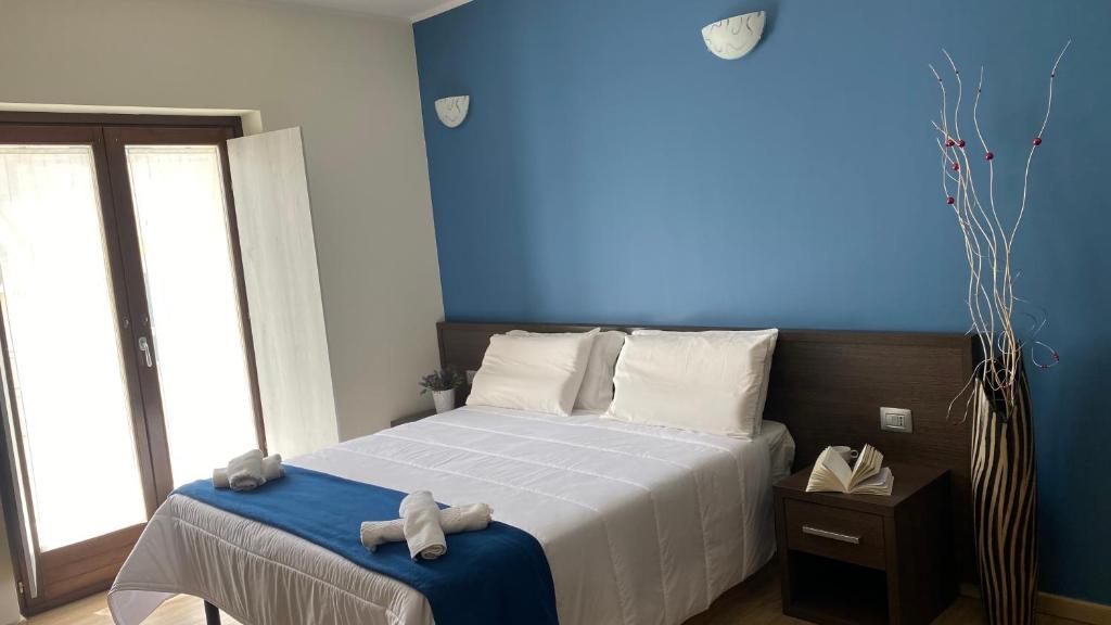 a bedroom with a bed with a blue wall at Residence Coccinella in Torre Melissa