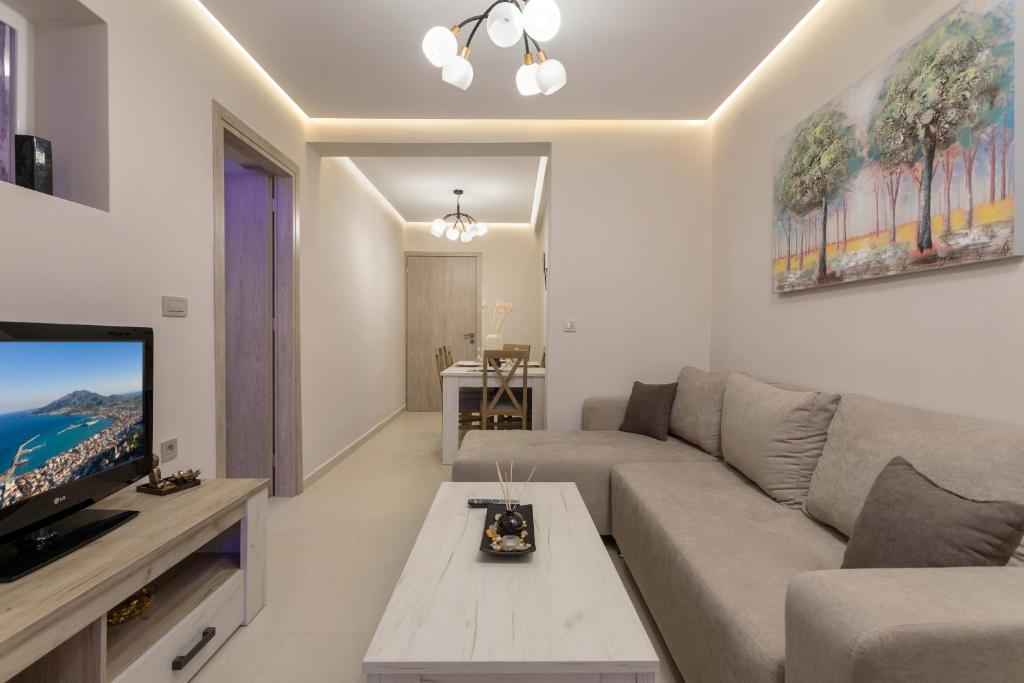 a living room with a couch and a tv at Evia's Apartment - New Apartment In Town! in Zakynthos Town