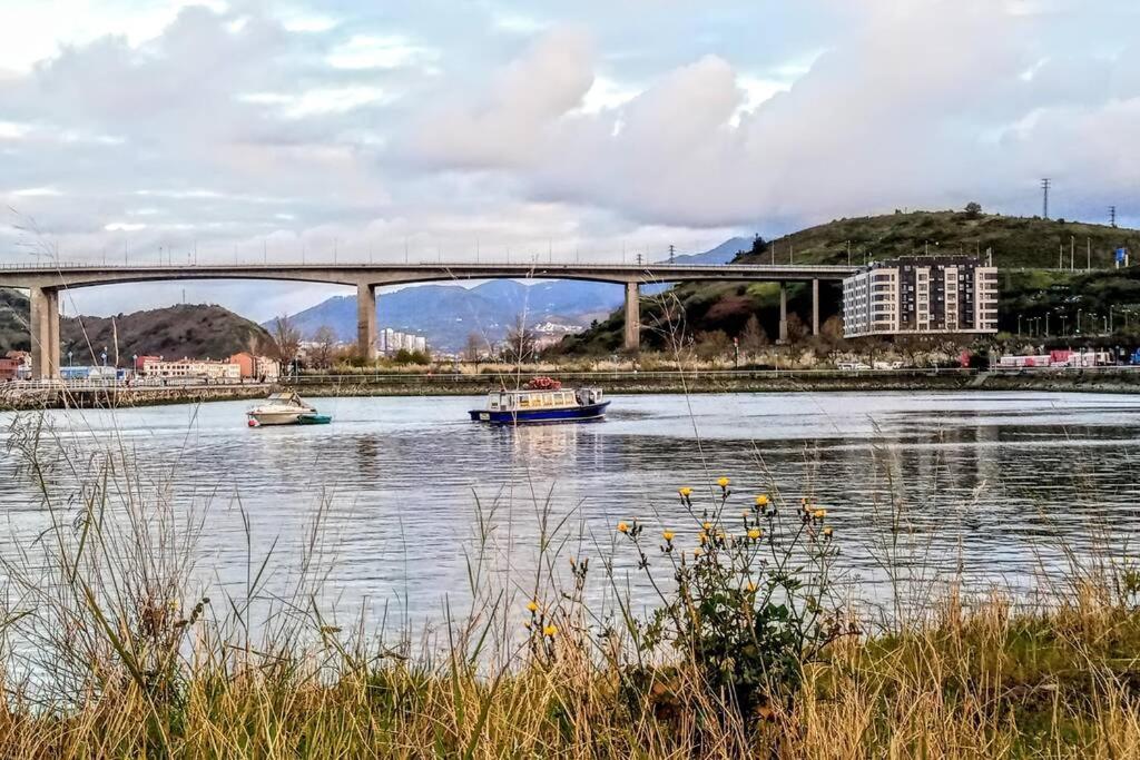 un puente sobre un río con barcos en el agua en RiverSide, en Barakaldo