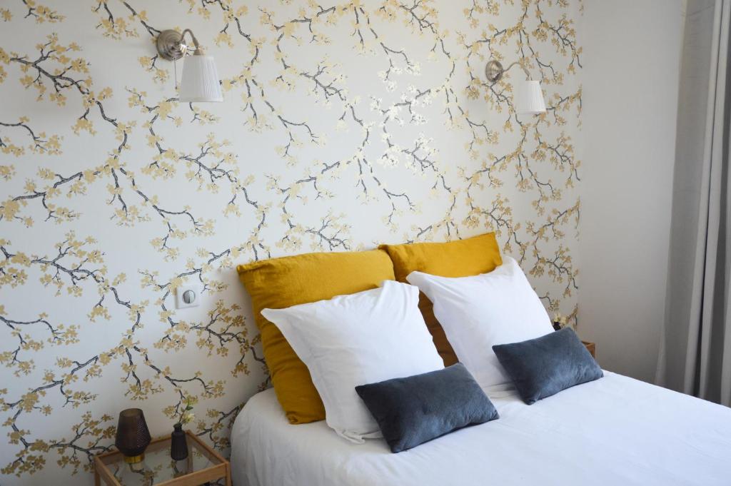 a bedroom with a bed with yellow and white pillows at Particulier in Ménétreux-le-Pitois