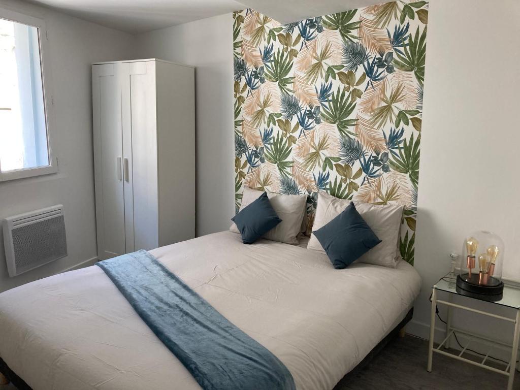 1 dormitorio con 1 cama con cabecero de flores en L'impressionnisme, en Agen