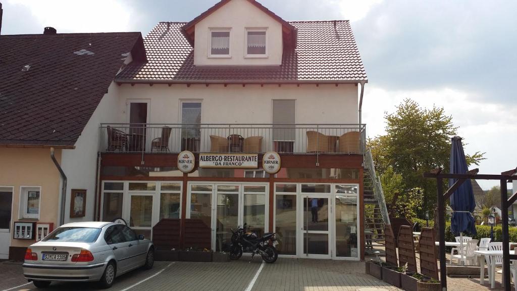 un edificio con un'auto parcheggiata di fronte di Albergo Restaurante Da Franco a Büchenbeuren